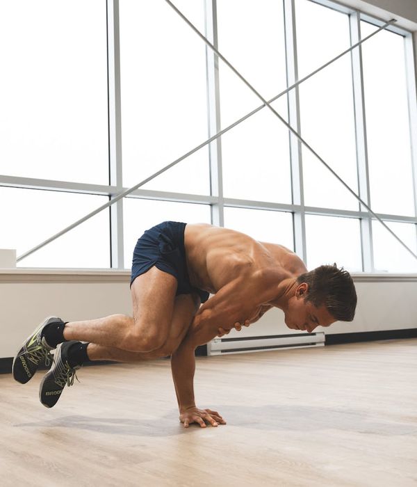 Man performing a controlled strength exercise in a bright studio.